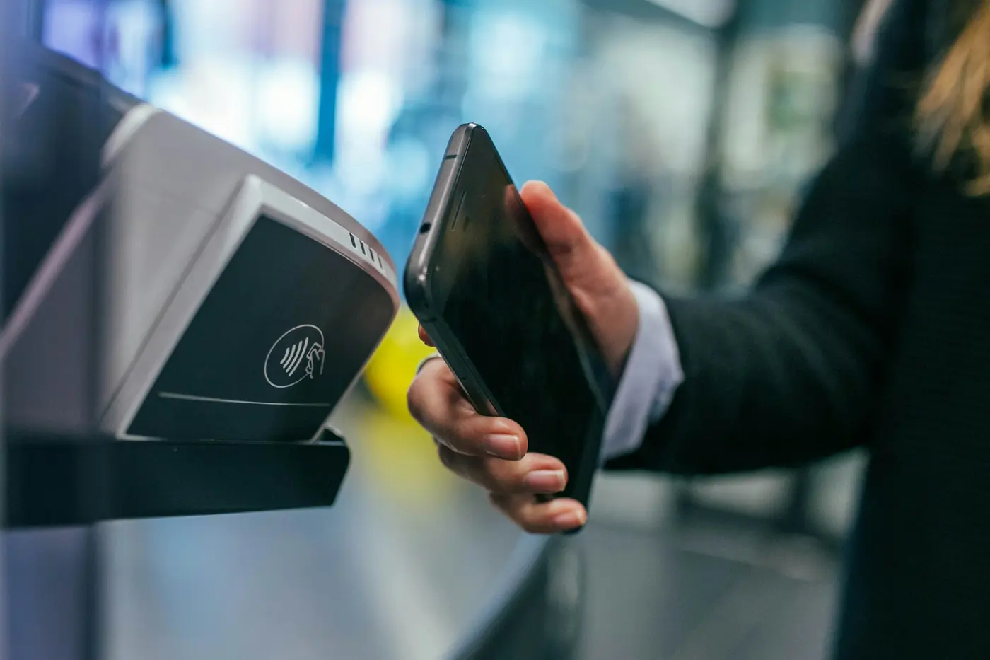 Persona pagando con su teléfono en una terminal