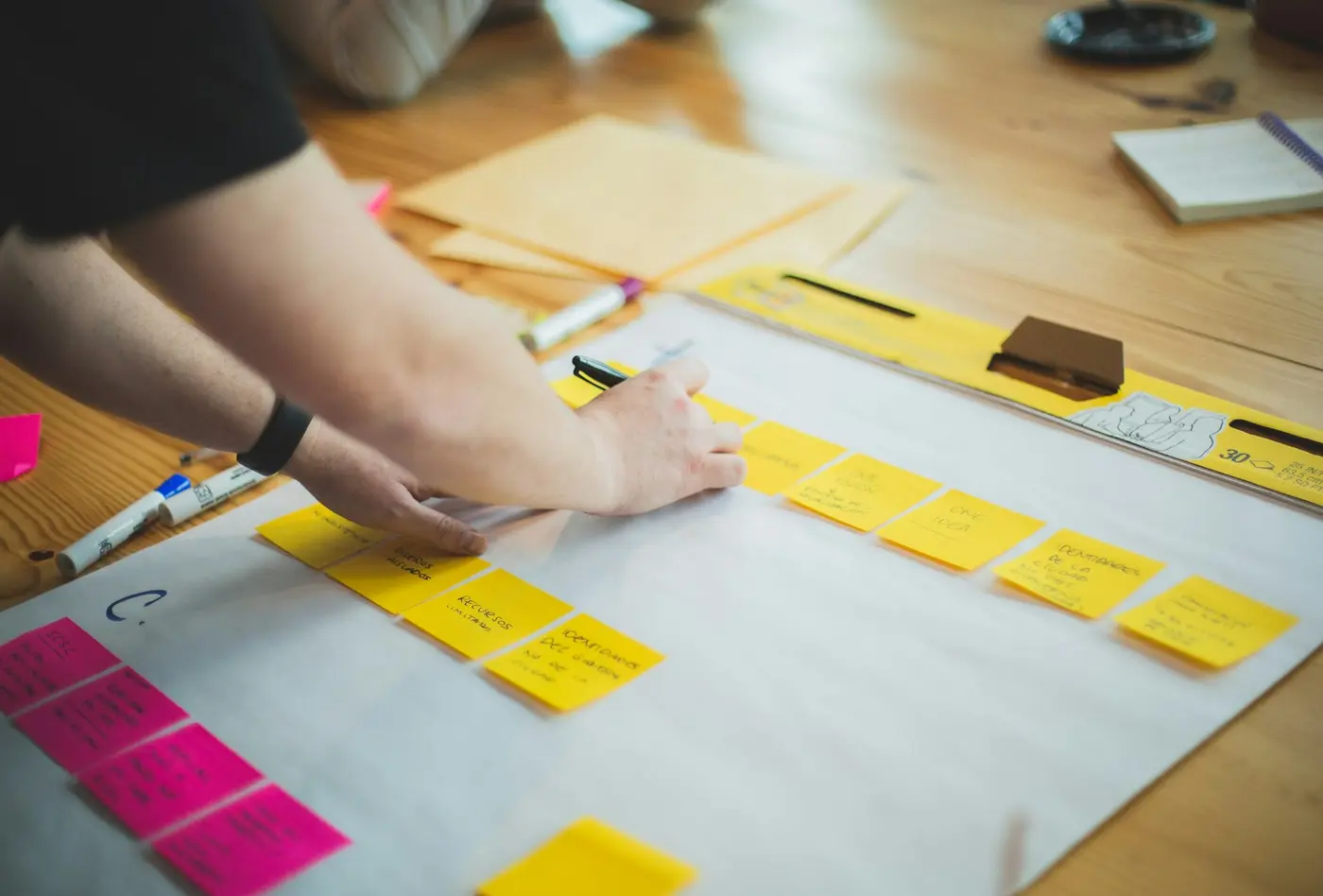 Persona construyendo un mapa con notas adhesivas amarillas